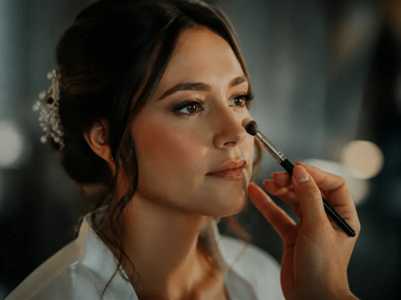 Geste de maquillage mariée au pinceau, gros plan sur les mains et les outils