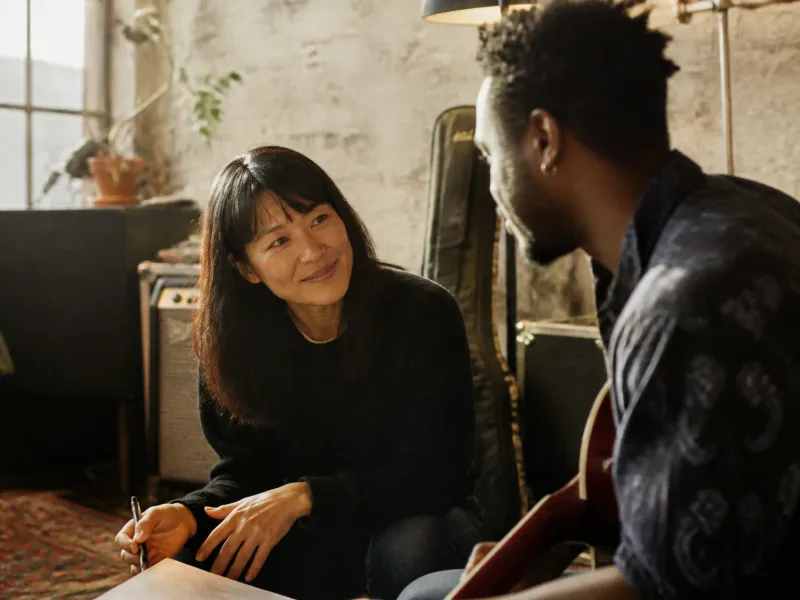 Portrait d’un membre de l’équipe souriant en coordination avec un musicien