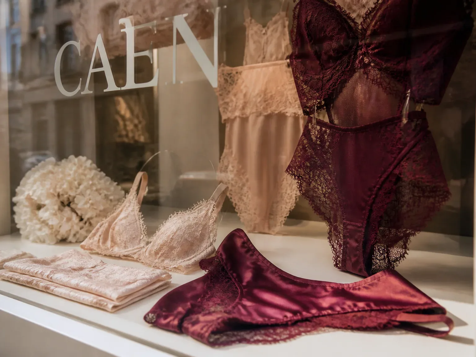 Packshot lingerie en vitrine en boutique à Caen, textures et couleurs douces