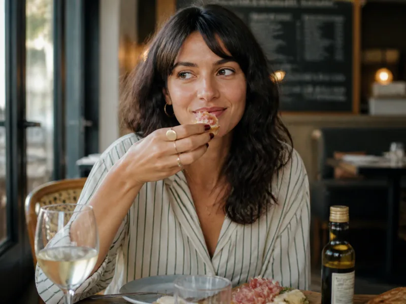 Client parisien dégustant un antipasti avec sourire détendu