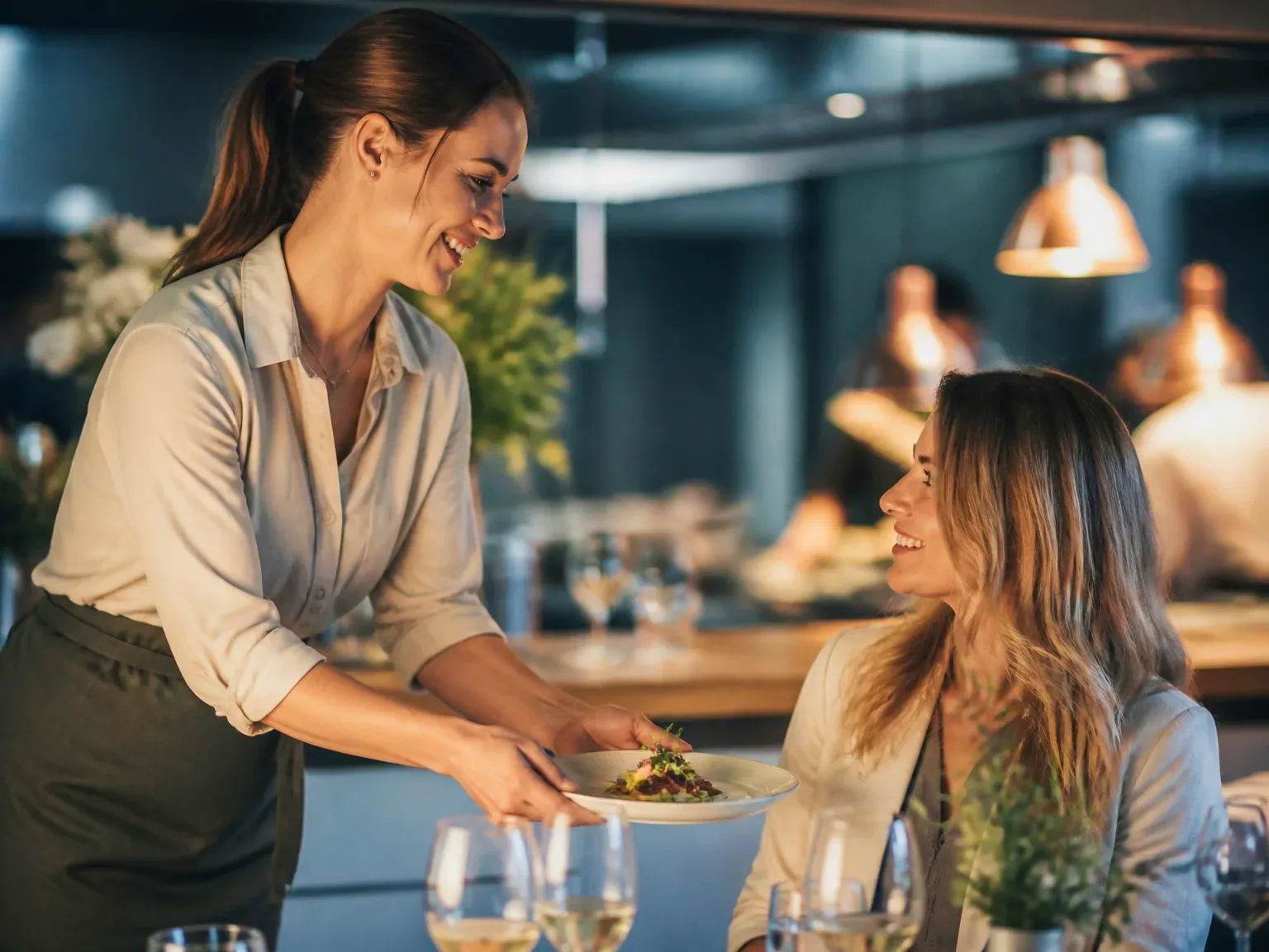 Service élégant présentant un plat lors d'un événement, ambiance chaleureuse